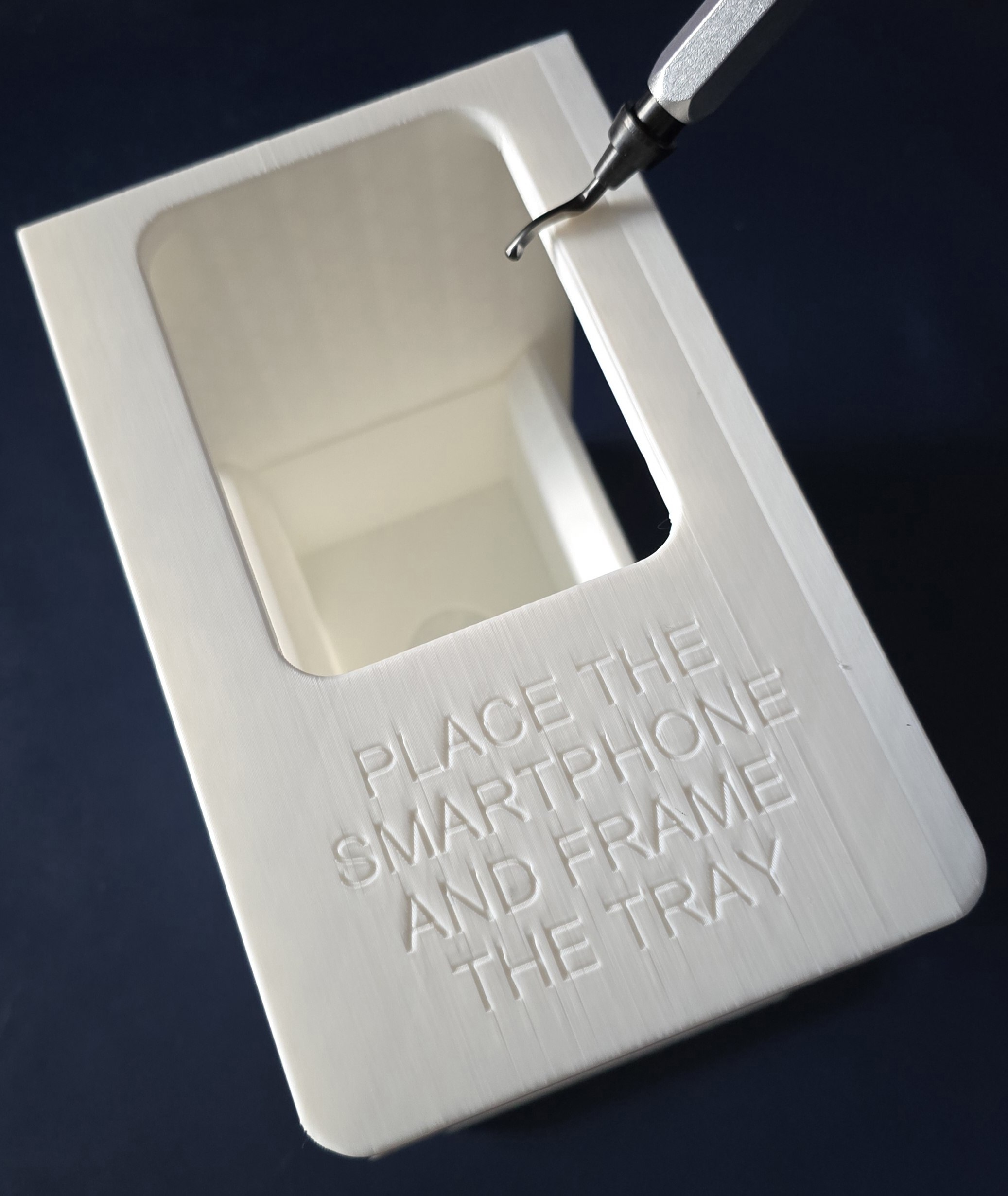 Deburring tool smoothing the edge of a 3D printed smartphone tray frame